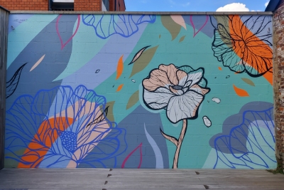 Fresque graphique de plusieurs fleurs sur un mur extérieur