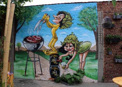 Deux trolls préparant un barbecue sous forme de fresque murale en trompe-l'oeil